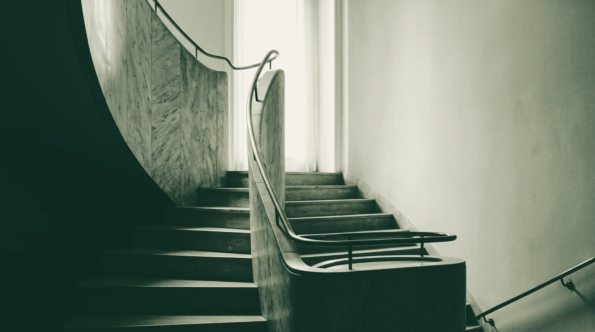 Escalera curva de mármol con pasamanos de latón